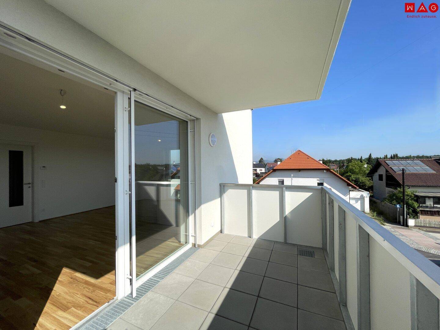 Geräumiger Balkon mit Fliesenboden und moderner Brüstung, ideal für Entspannung im Freien.