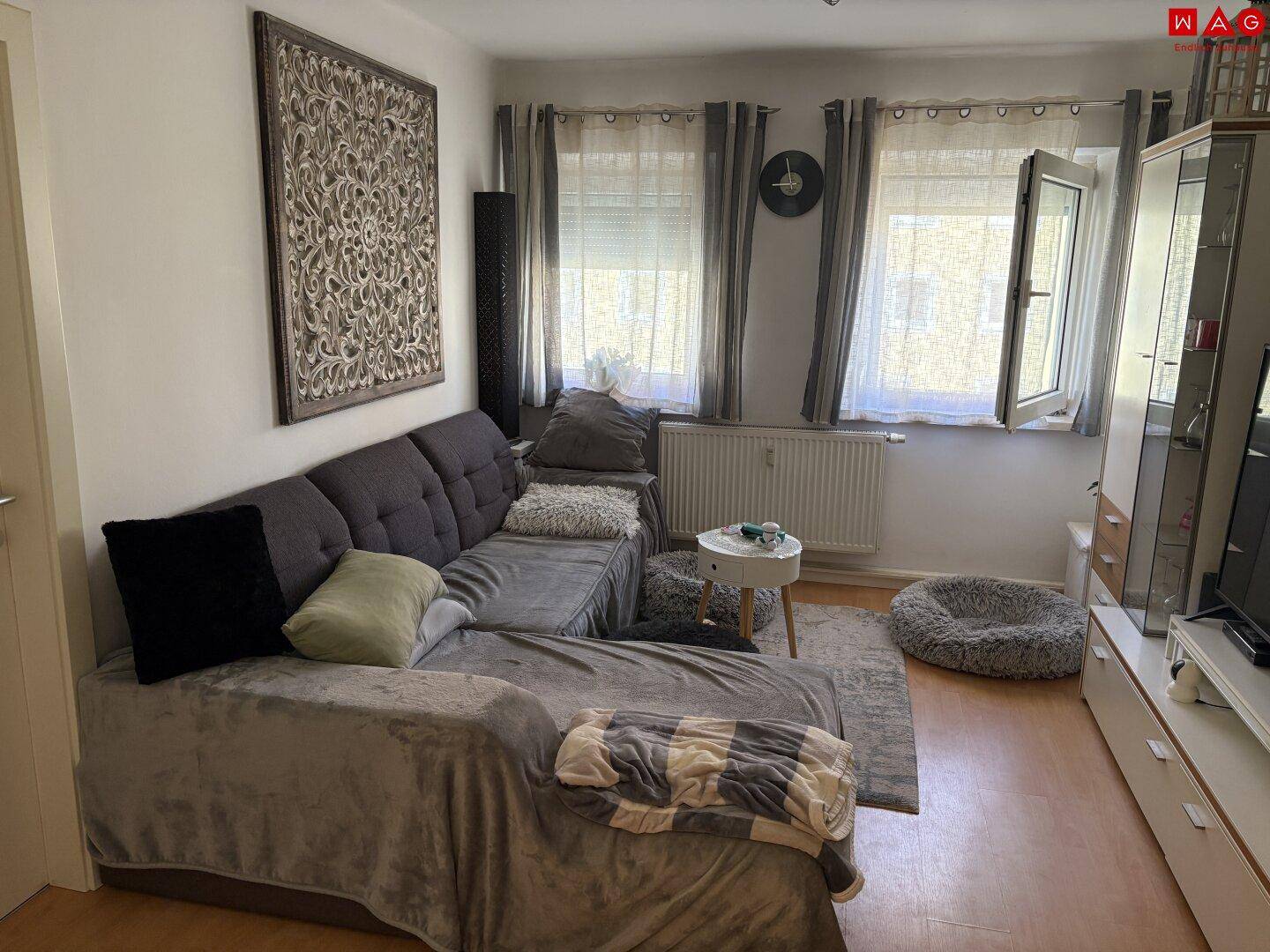 Gemütliches Wohnzimmer mit großem Ecksofa, TV-Möbel und viel Tageslicht.