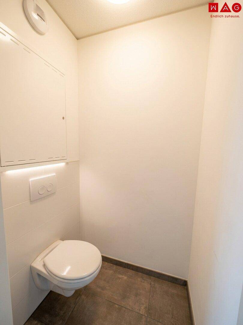 Separates Gäste-WC mit wandhängendem WC und integriertem Spülkasten, sauber und praktisch.