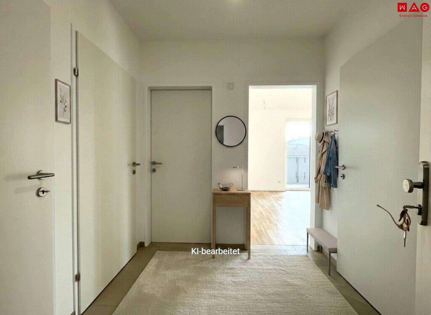 Heller Flur mit weißen Türen, Spiegel und Garderobe, der zu weiteren Räumen führt.