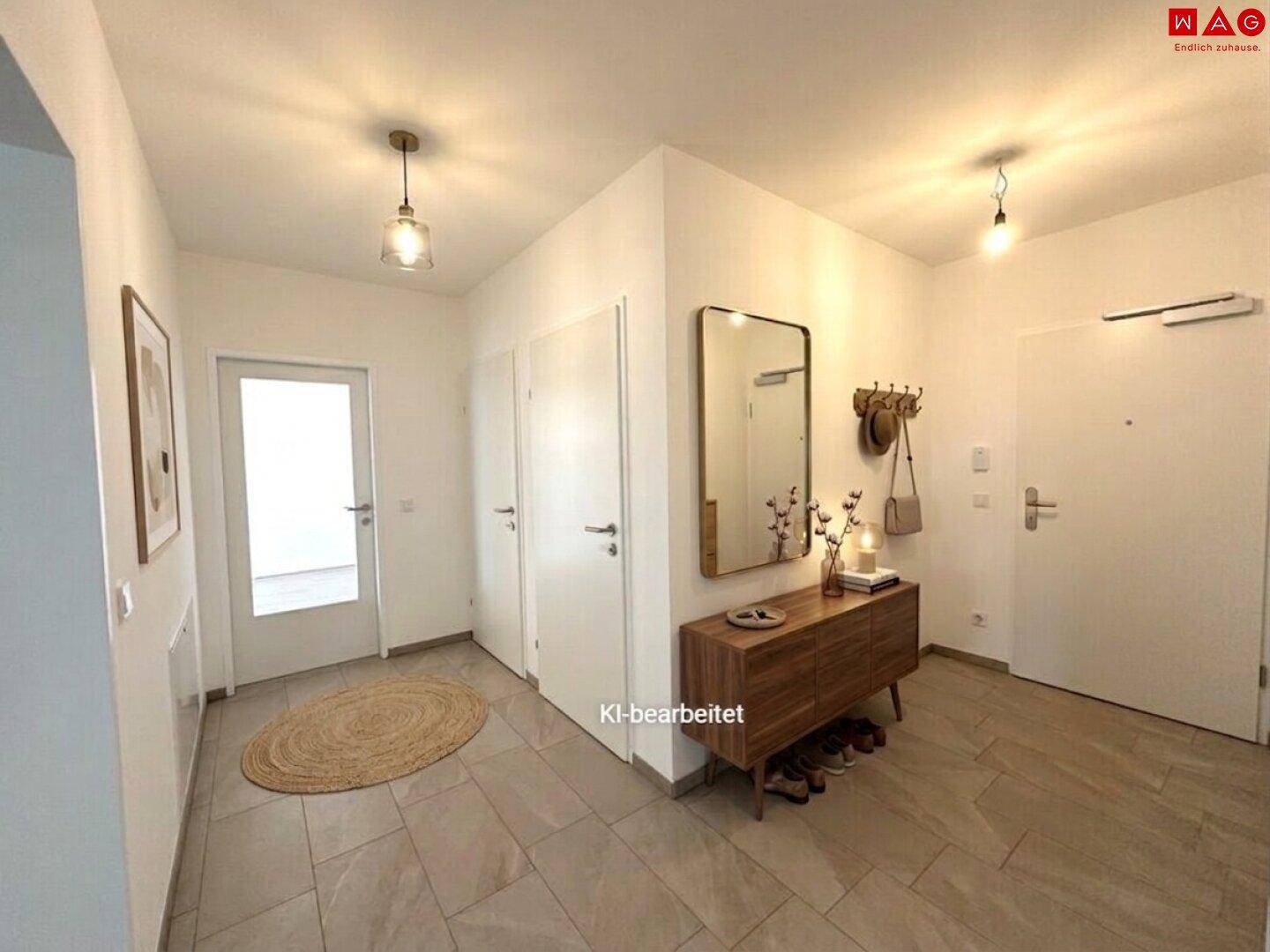 Heller Eingangsbereich mit Fliesenboden, Garderobe und modernem Spiegel.