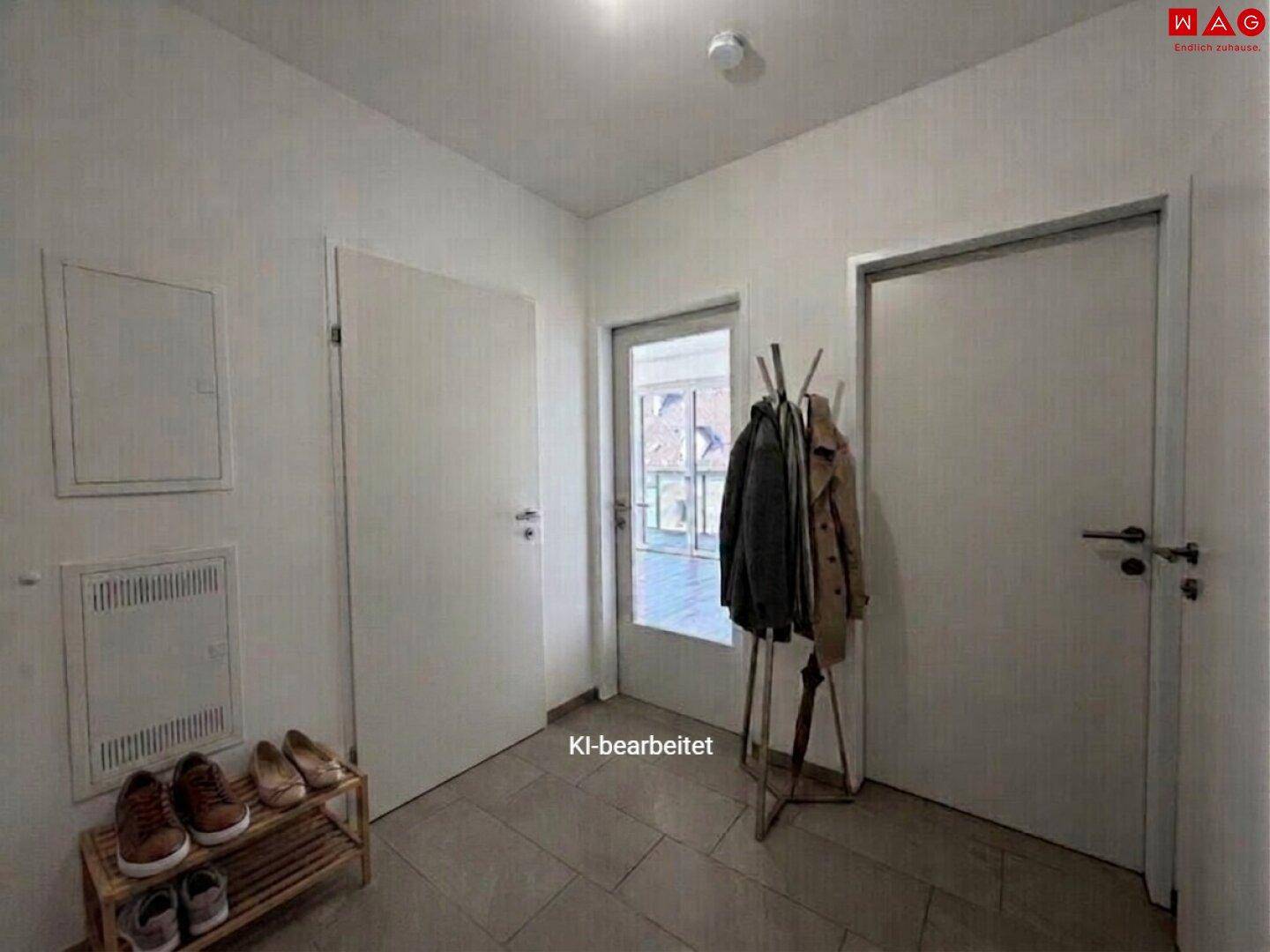 Heller Eingangsbereich mit Fliesenboden, Garderobe und Schuhregal.