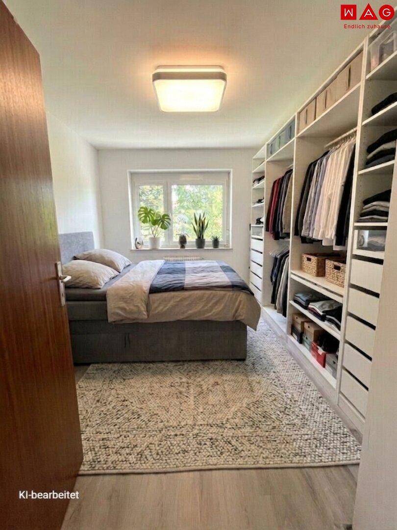 Helles Schlafzimmer mit großem Bett, Einbauschränken und Fenster mit Blick ins Grüne.