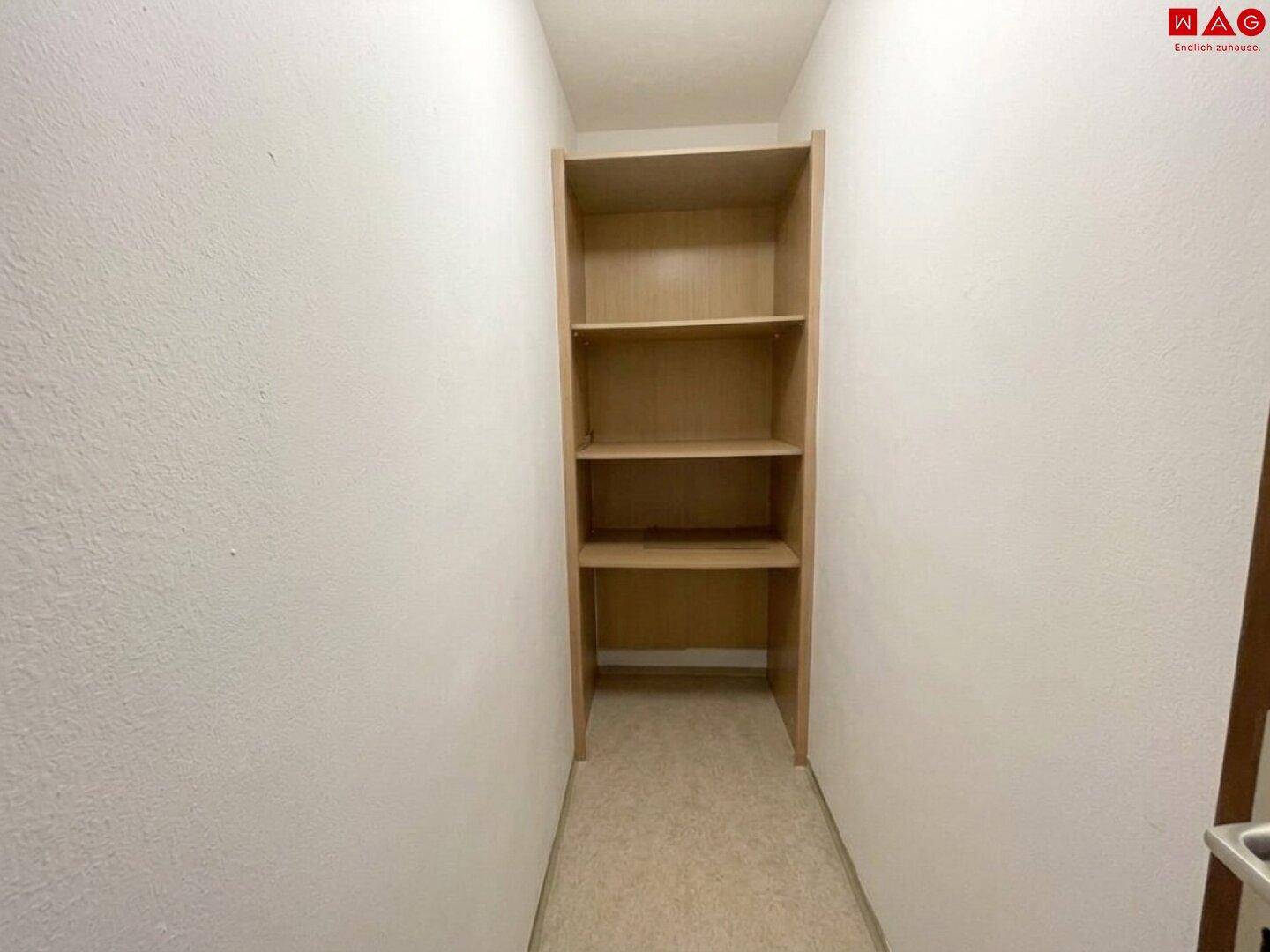 Schmaler Raum mit praktischem Einbauregal und hellem Boden, ideal als Abstellraum.