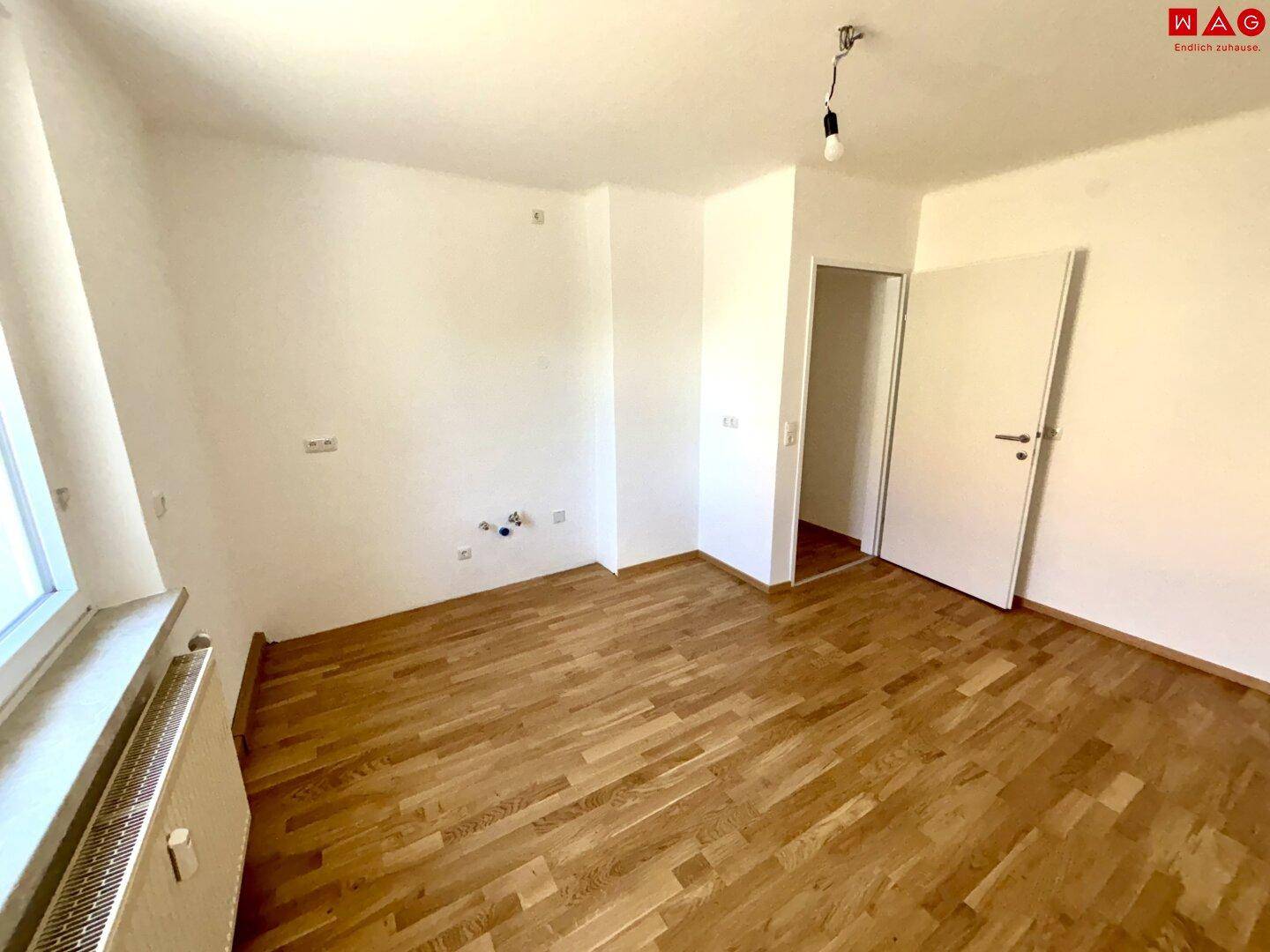 Helles Zimmer mit Parkettboden und weiß gestrichenen Wänden, bereit zum Einzug.