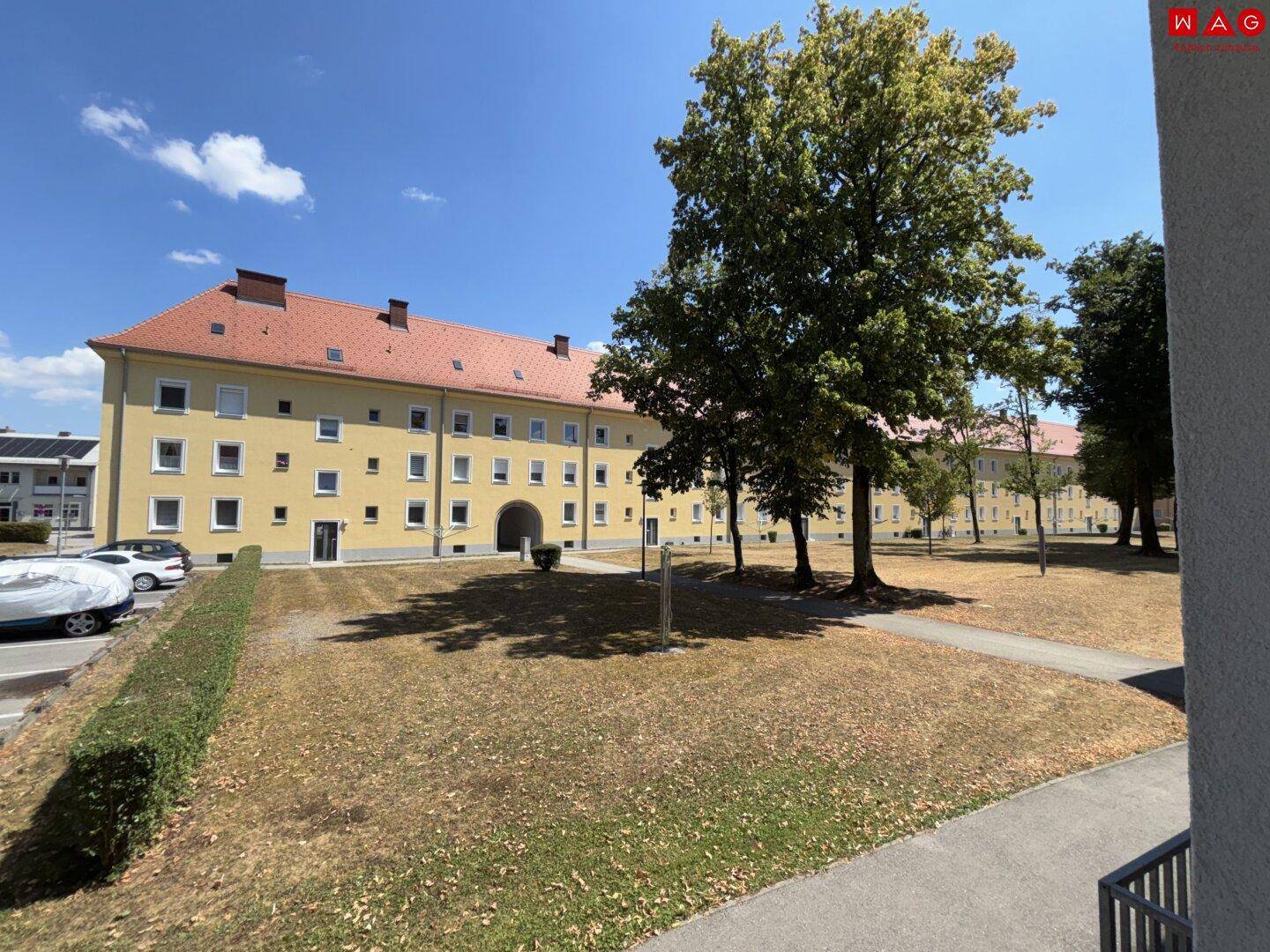 Außenansicht des Wohngebäudes mit rotem Ziegeldach und gepflegter Grünfläche.