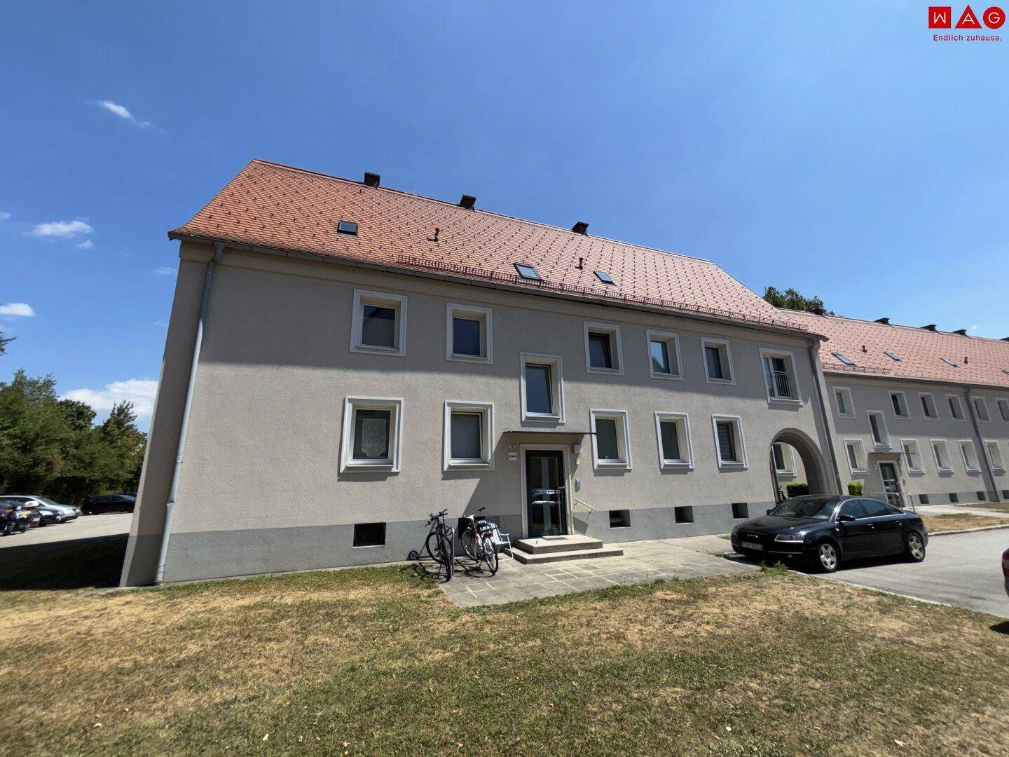 Fassade des Wohngebäudes mit Eingangsbereich und Fahrrädern davor.