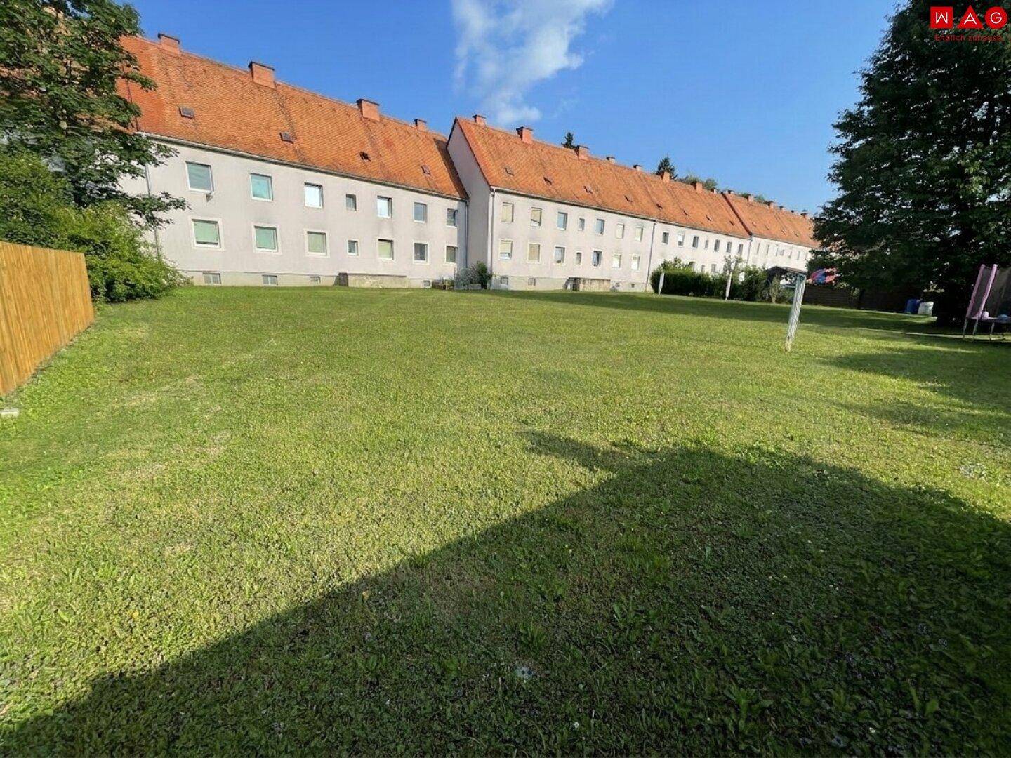 Weitläufige Rasenfläche im Gemeinschaftsgarten hinter dem Wohngebäude.