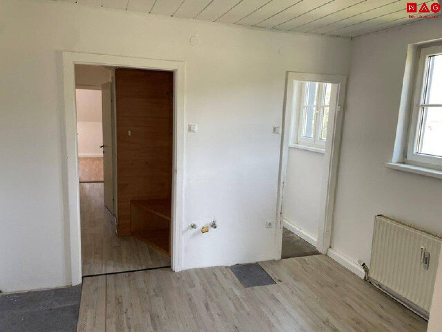 Heller Raum mit Holzbalkendecke und Zugang zu weiteren Zimmern im Obergeschoss.