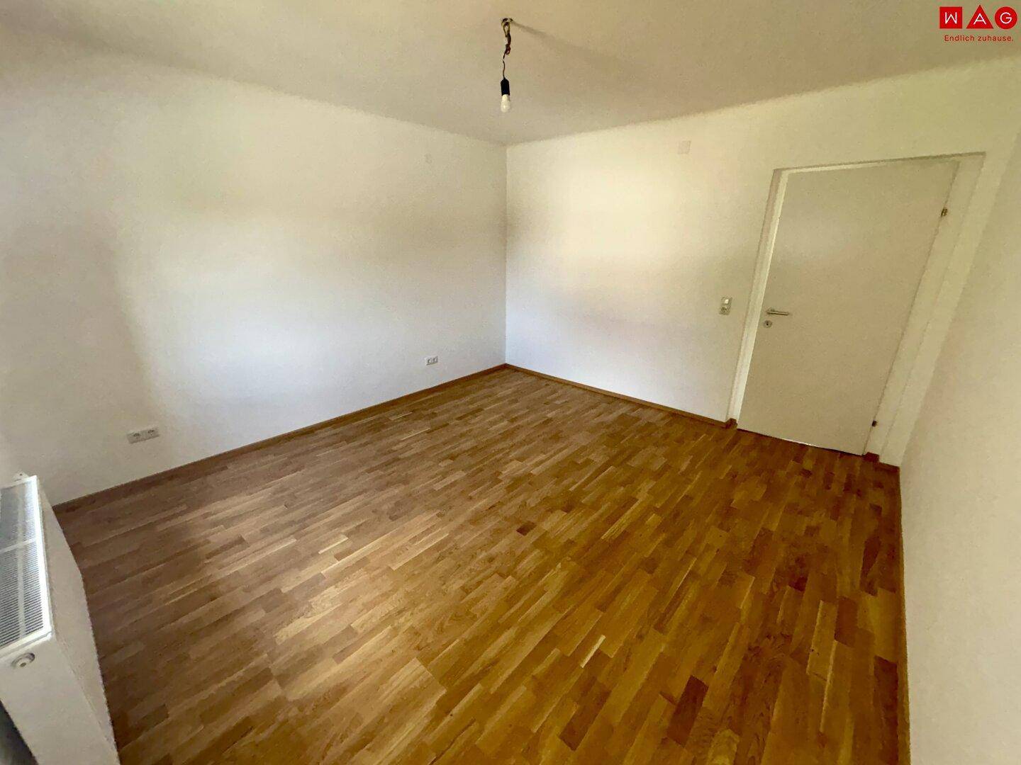 Geräumiges Schlafzimmer mit Parkettboden und weiß gestrichenen Wänden, ideal für individuelle Einrichtung.