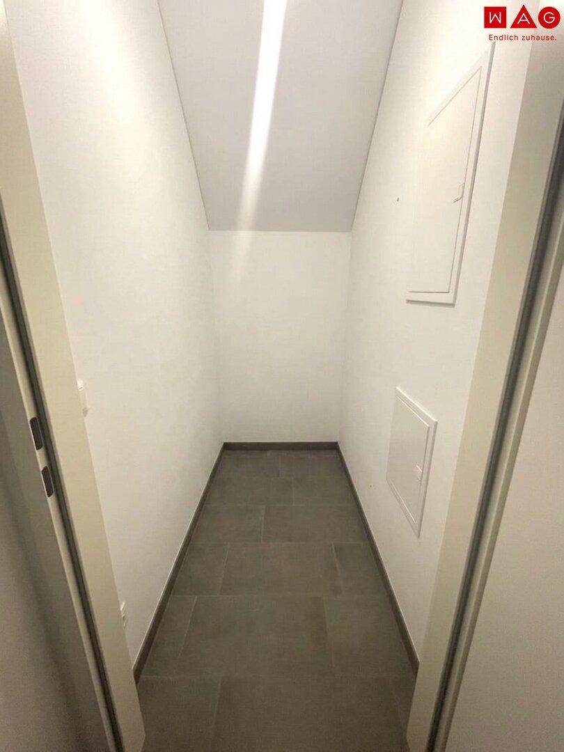 Praktischer Abstellraum mit Fliesenboden und schräger Decke, ideal für zusätzlichen Stauraum.