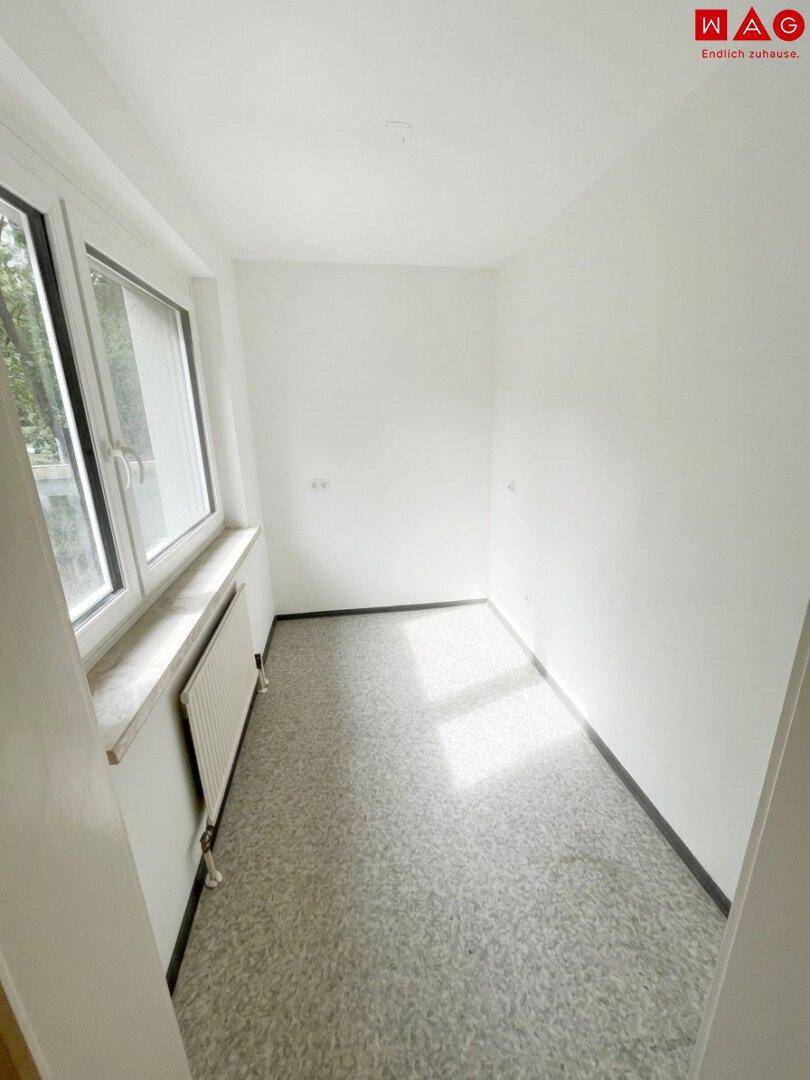 Heller, leerer Raum mit Fenster und Fliesenboden, ideal als Abstellraum oder kleines Büro.