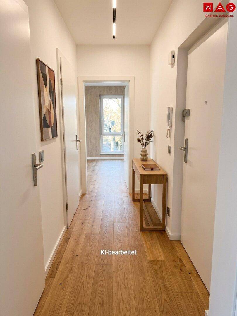 Heller Flur mit Holzboden und einer Konsole, die zu weiteren Räumen führt.
