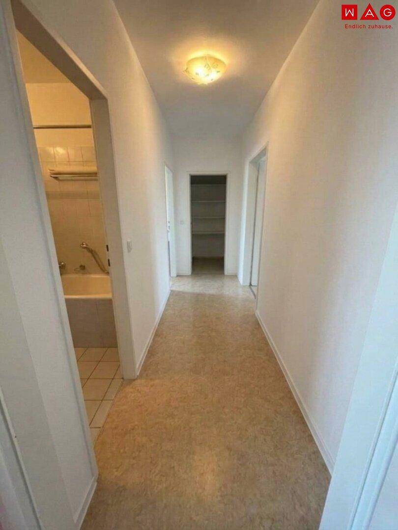 Heller Flur mit Fliesenboden und Zugang zu verschiedenen Räumen der Wohnung.