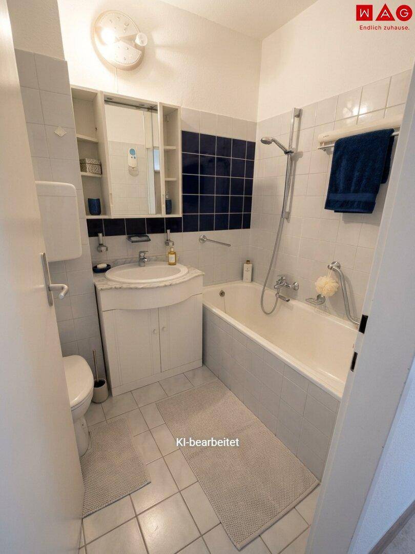 Badezimmer mit Badewanne, Dusche, Waschbecken und Spiegel, in klassischem Design.