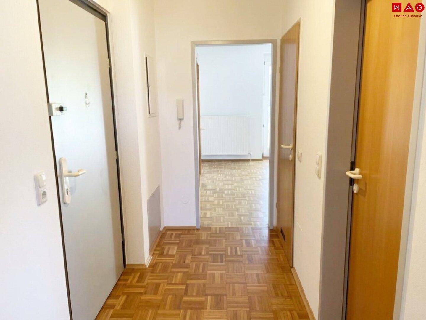 Heller Flur mit Parkettboden und Zugang zu den angrenzenden Räumen.
