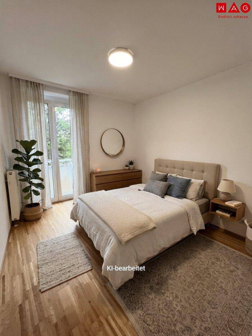 Helles Schlafzimmer mit Holzboden, beigem Bett und Zugang zu einem Balkon mit Grünblick.