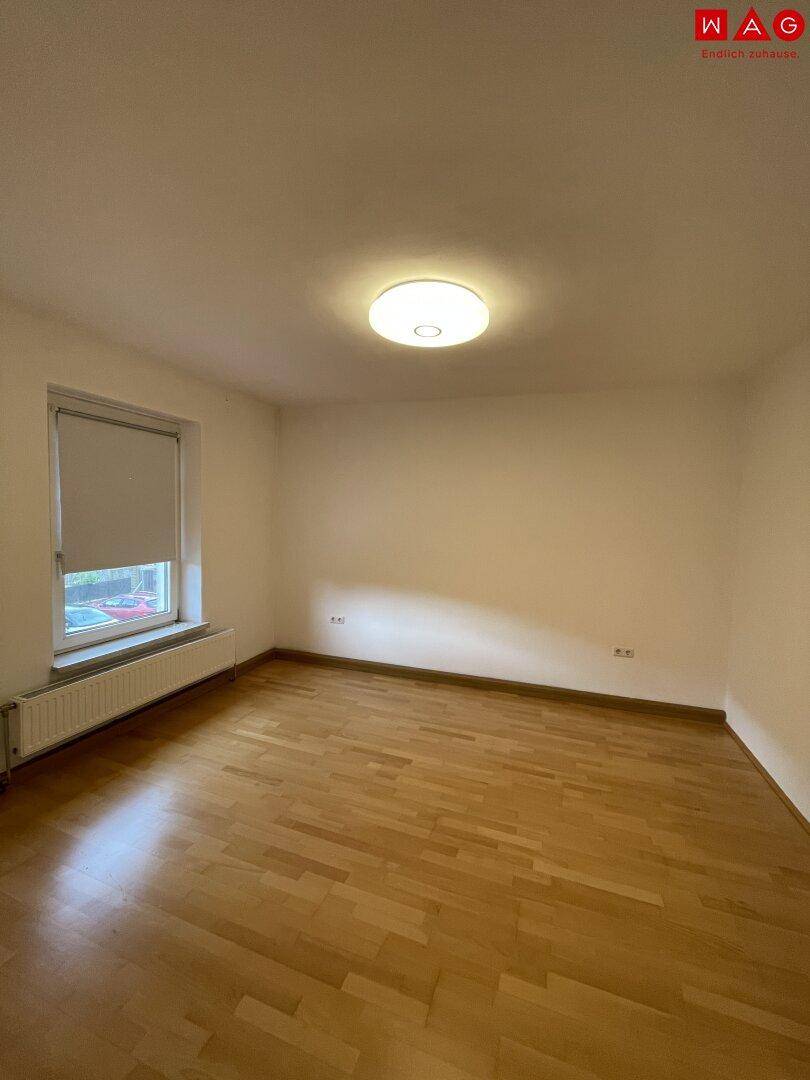 Heller Raum mit Parkettboden und Fenster, vielseitig nutzbar als Schlaf- oder Arbeitszimmer.