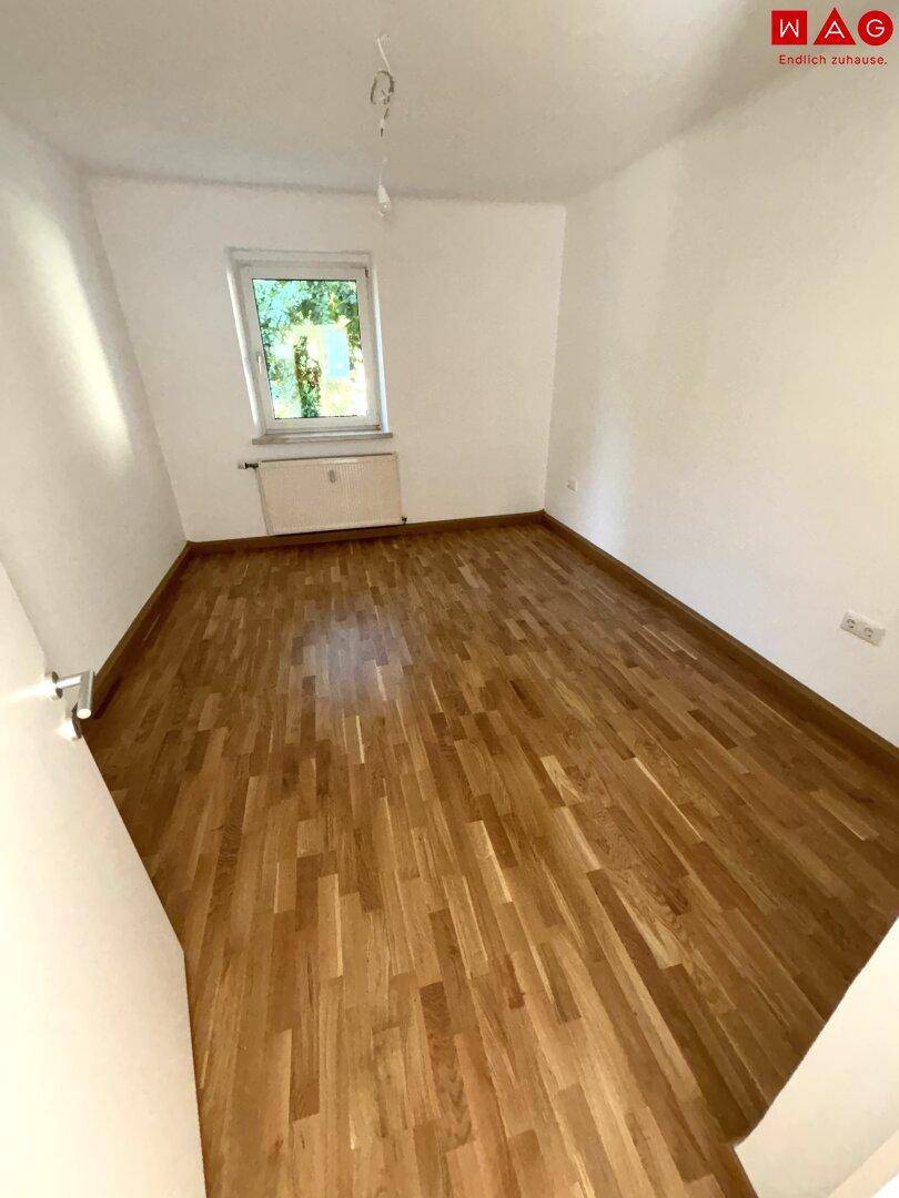Gemütliches Zimmer mit Parkettboden und einem Fenster, ideal als Schlaf- oder Arbeitszimmer.