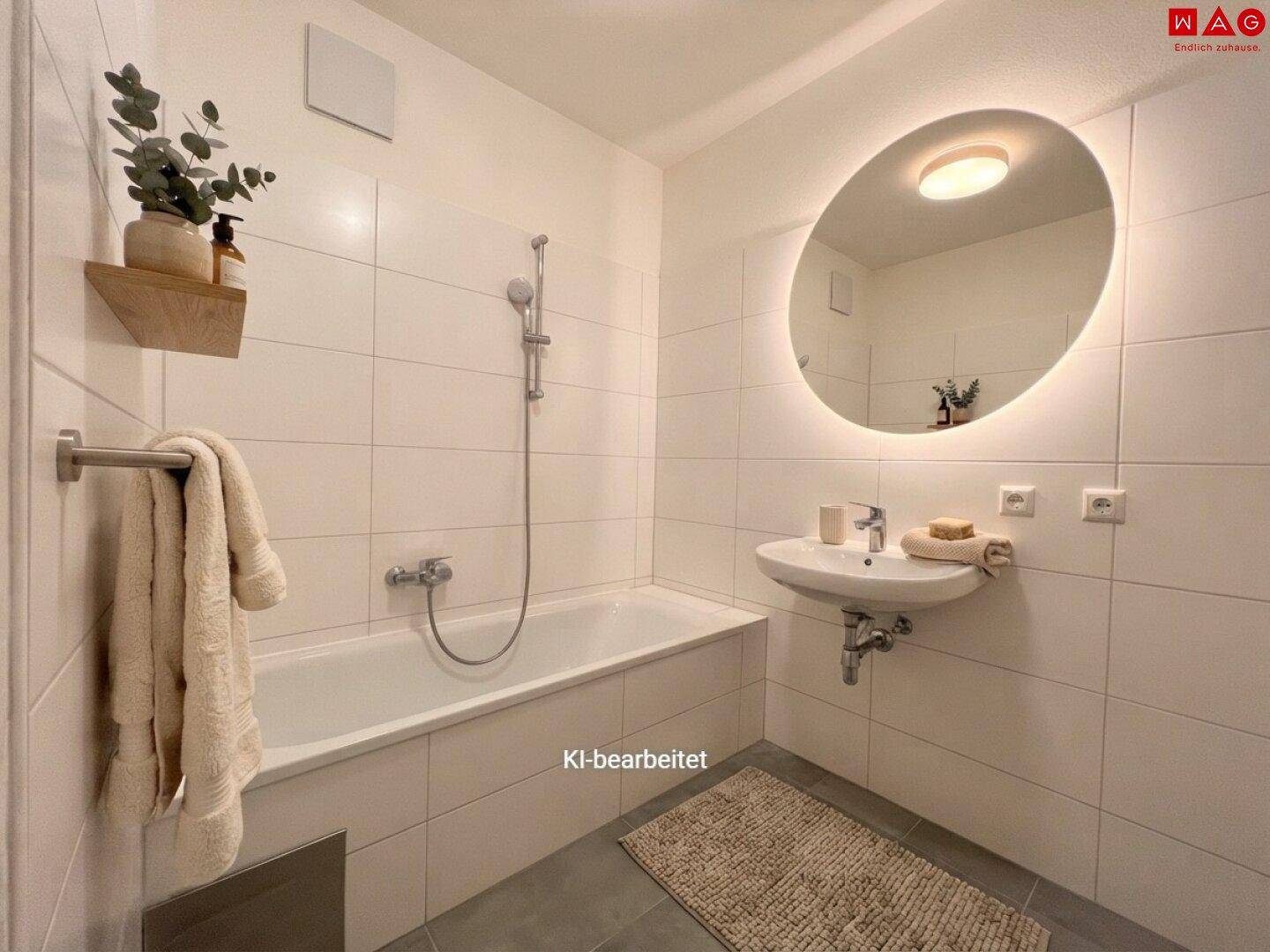 Modernes Badezimmer mit Badewanne, Einzelwaschbecken und beleuchtetem Spiegel.