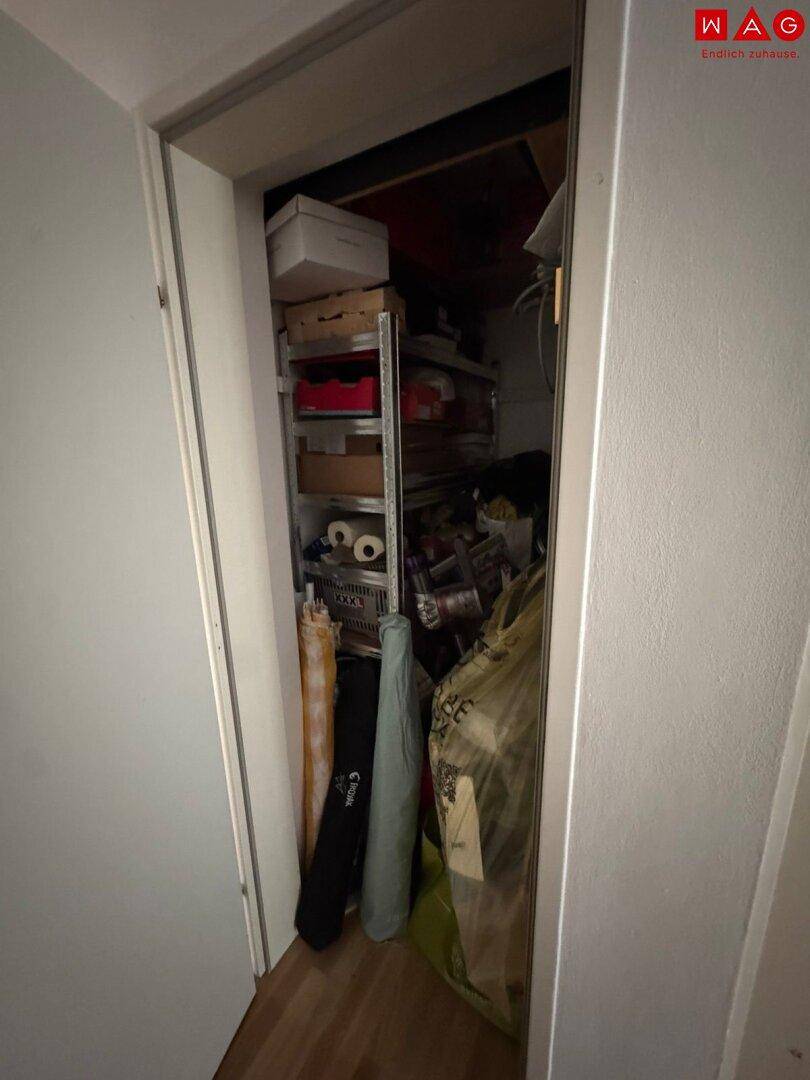 Kleiner Abstellraum mit Regalen und verschiedenen Haushaltsgegenständen, bietet zusätzlichen Stauraum.
