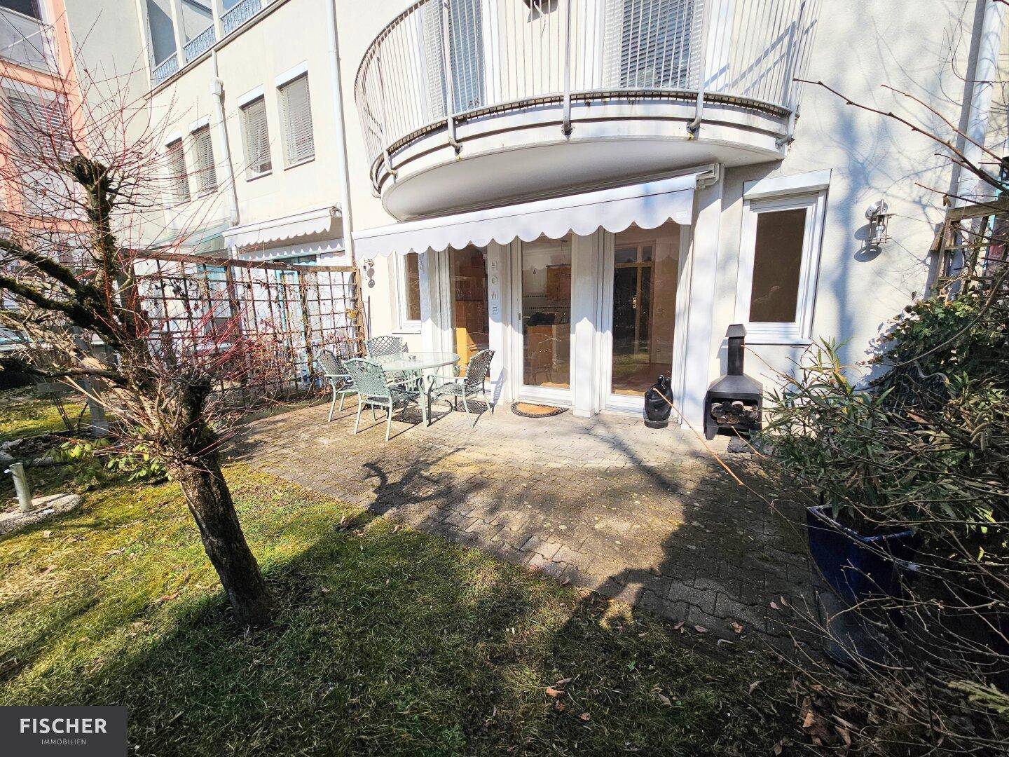 Außenansicht des Gebäudes mit Terrasse, Garten und einem Balkon im Obergeschoss.
