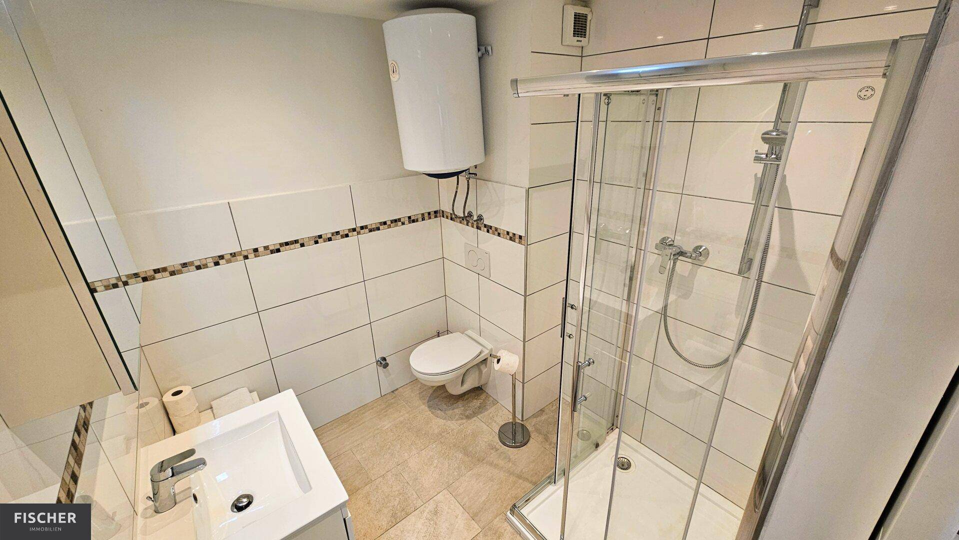 Modernes Badezimmer mit Duschkabine, wandhängendem WC und Waschbecken mit Spiegelschrank.