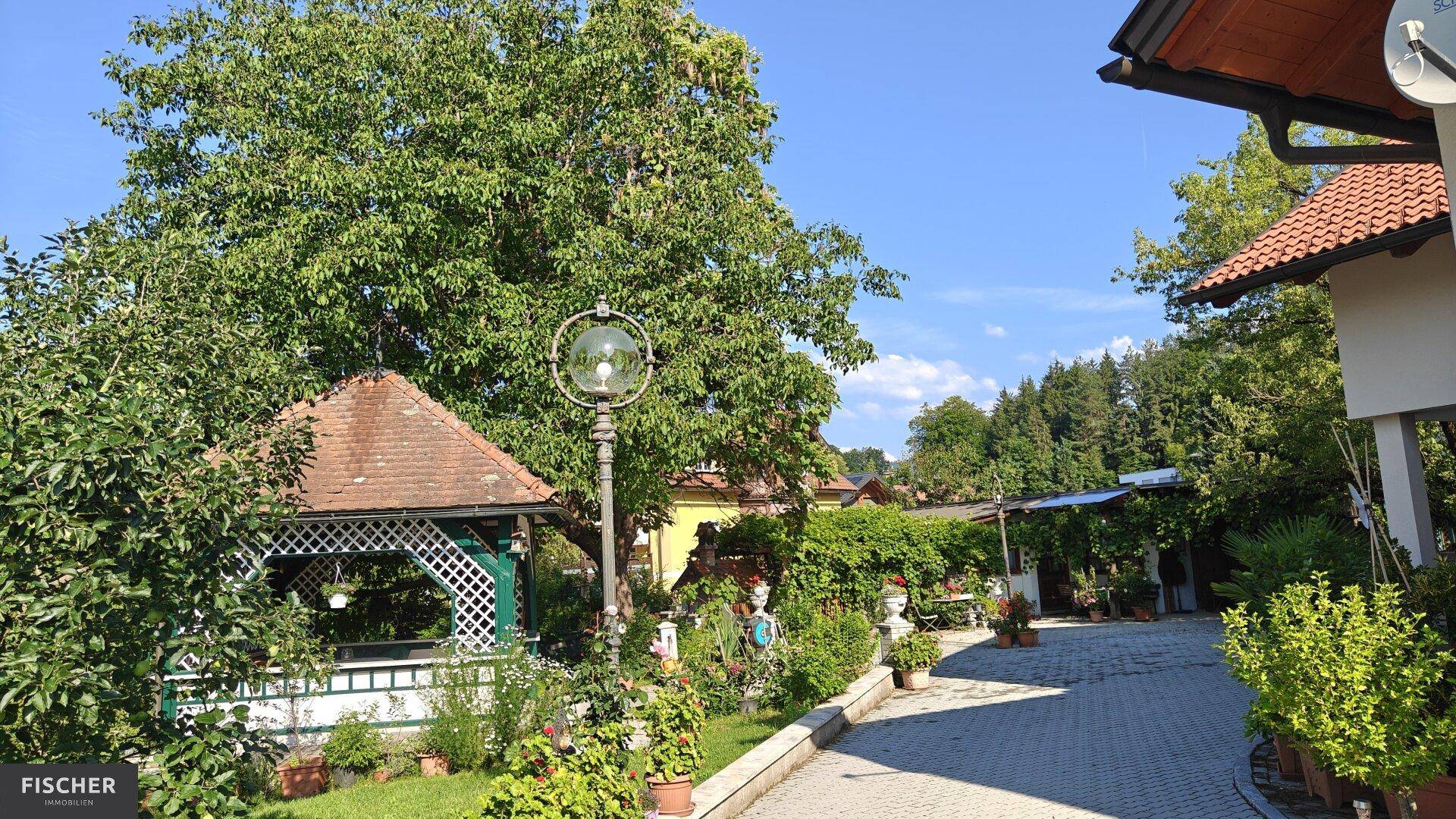 Gepflegter Gartenbereich mit einem charmanten Pavillon, Laterne und üppiger Bepflanzung.