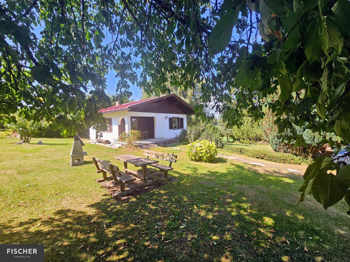 Idyllischer Gartenbereich mit Sitzgelegenheiten im Freien und dem charmanten Landhaus im Hintergrund.