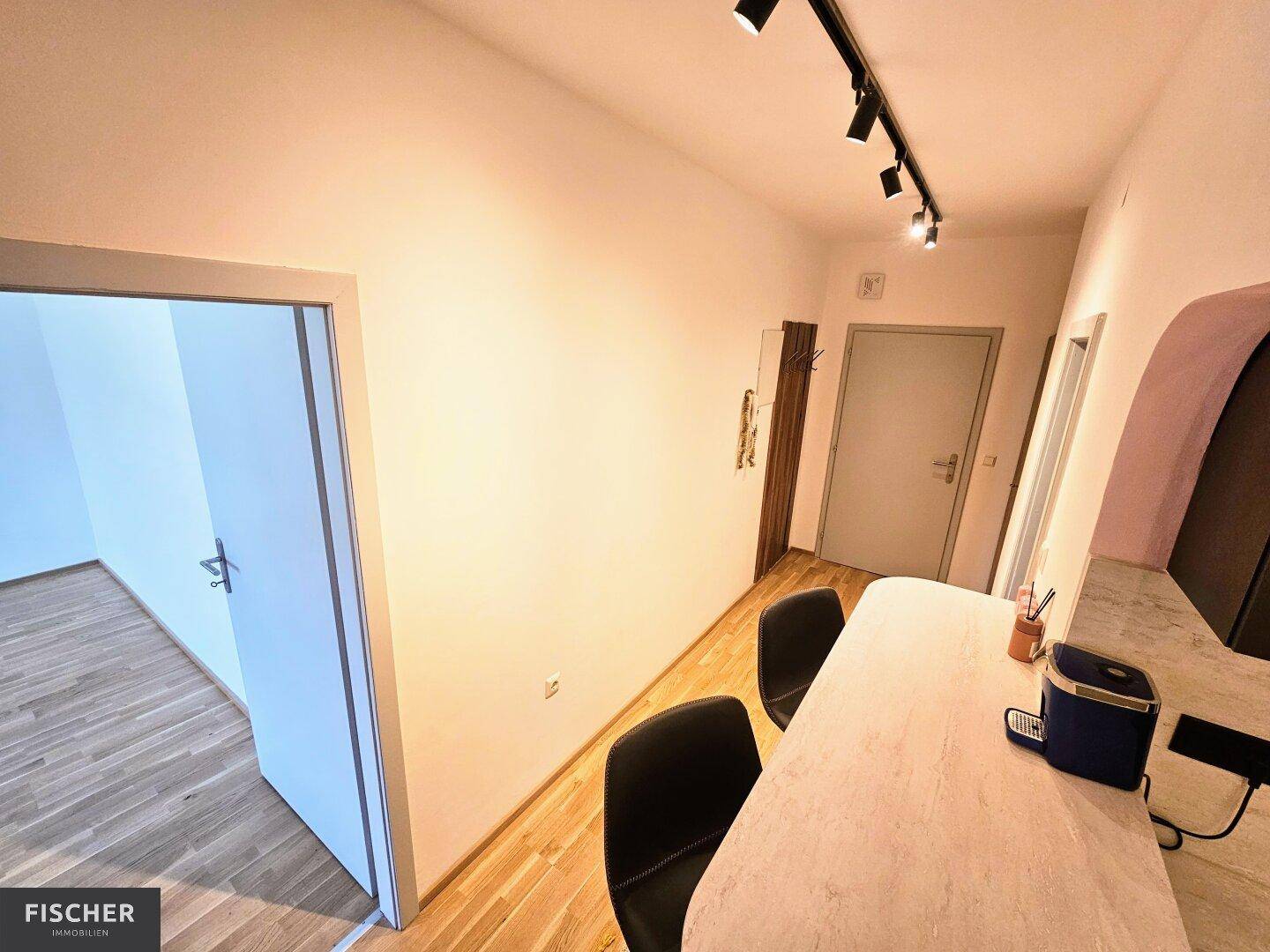 Heller Flurbereich mit Holzboden und Zugang zu verschiedenen Räumen, inklusive Garderobenbereich.