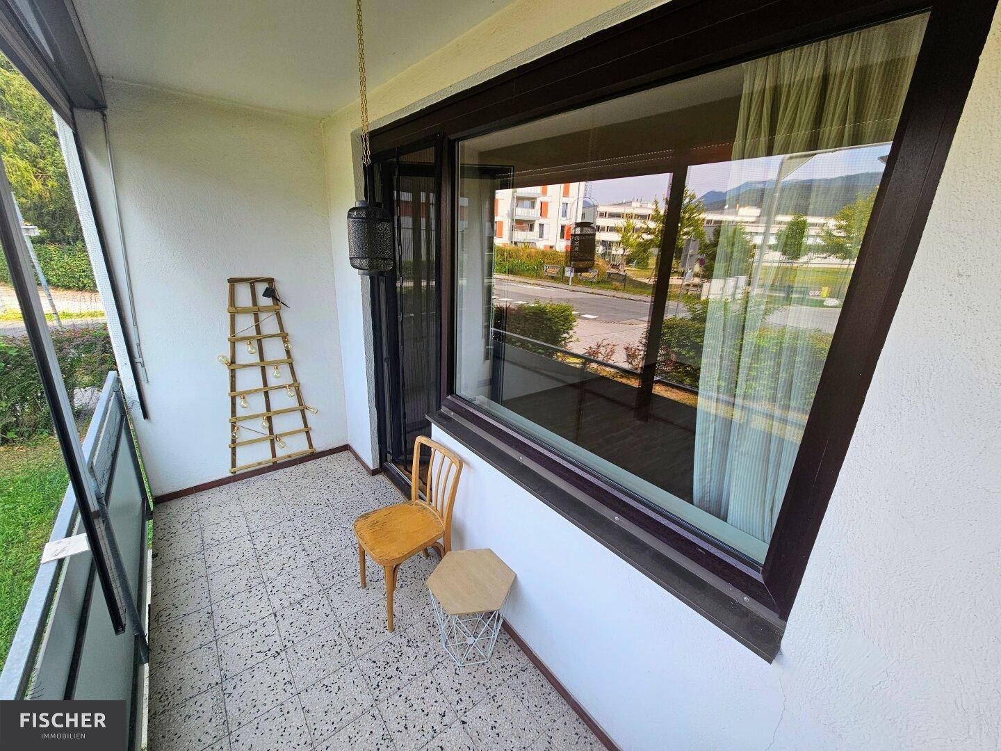 Gemütlicher Balkon mit Fliesenboden und einfacher Bestuhlung, ideal für entspannte Stunden.