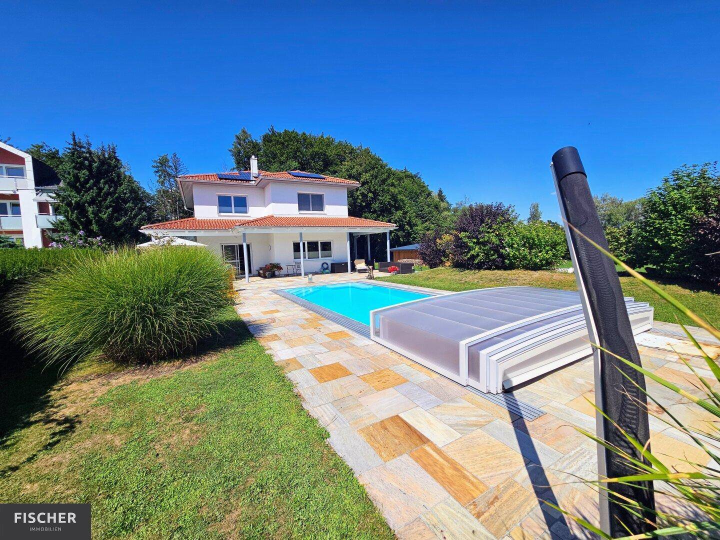 Freistehendes Haus mit Pool, großem Garten und Photovoltaikanlage auf dem Dach.