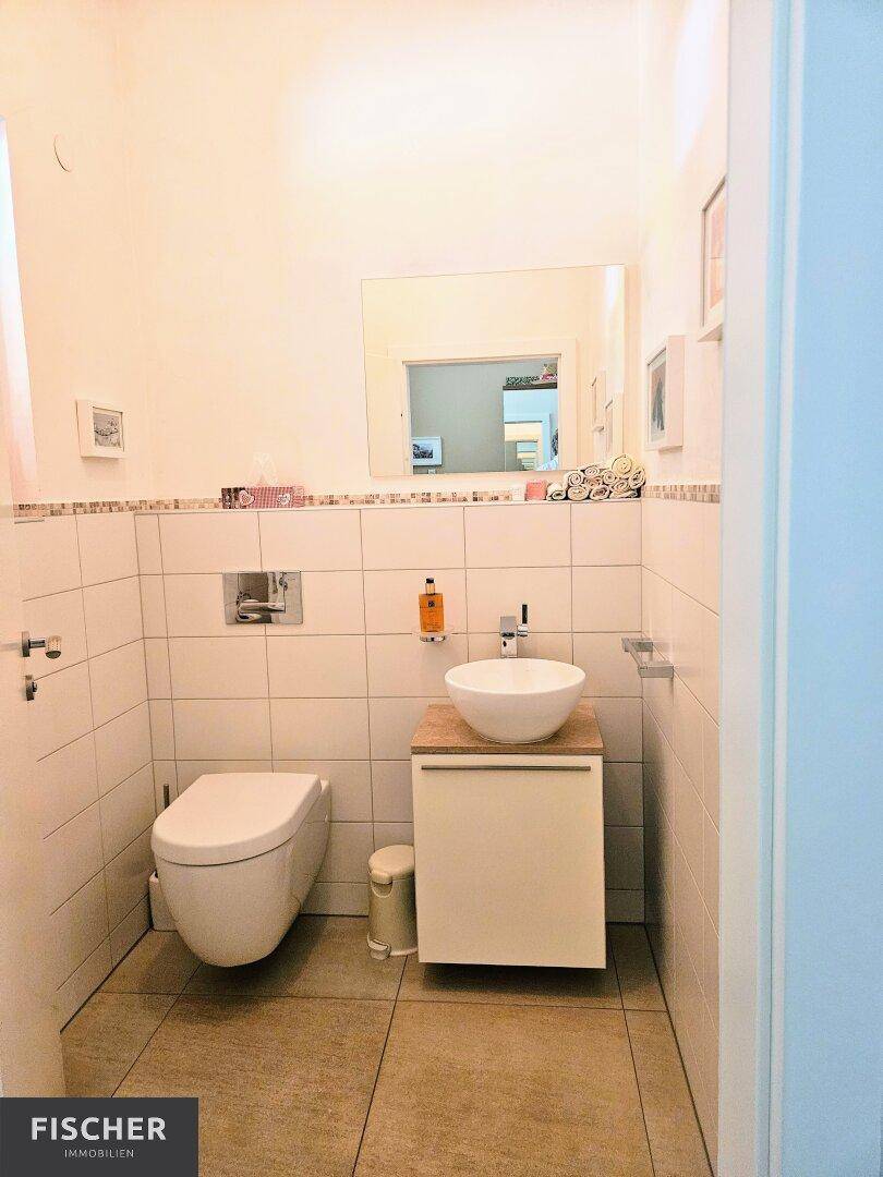 Modernes Gäste-WC mit wandhängender Toilette und Aufsatzwaschbecken.