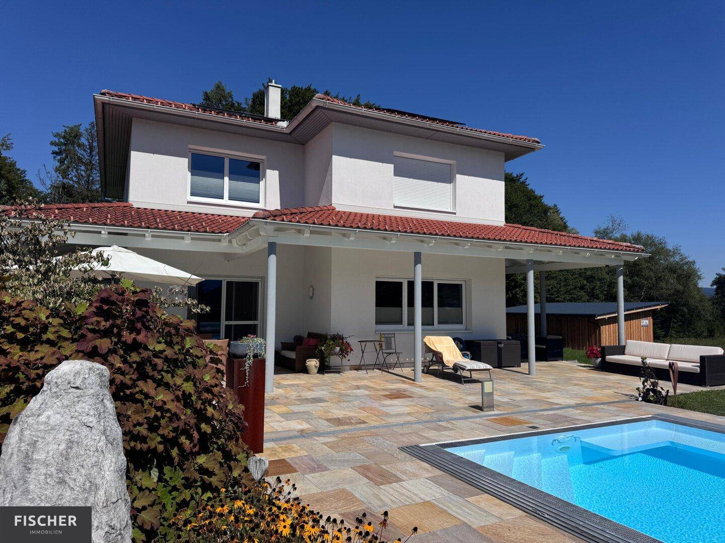 Modernes Einfamilienhaus mit großer Terrasse, Pool und Garten in sonniger Lage.