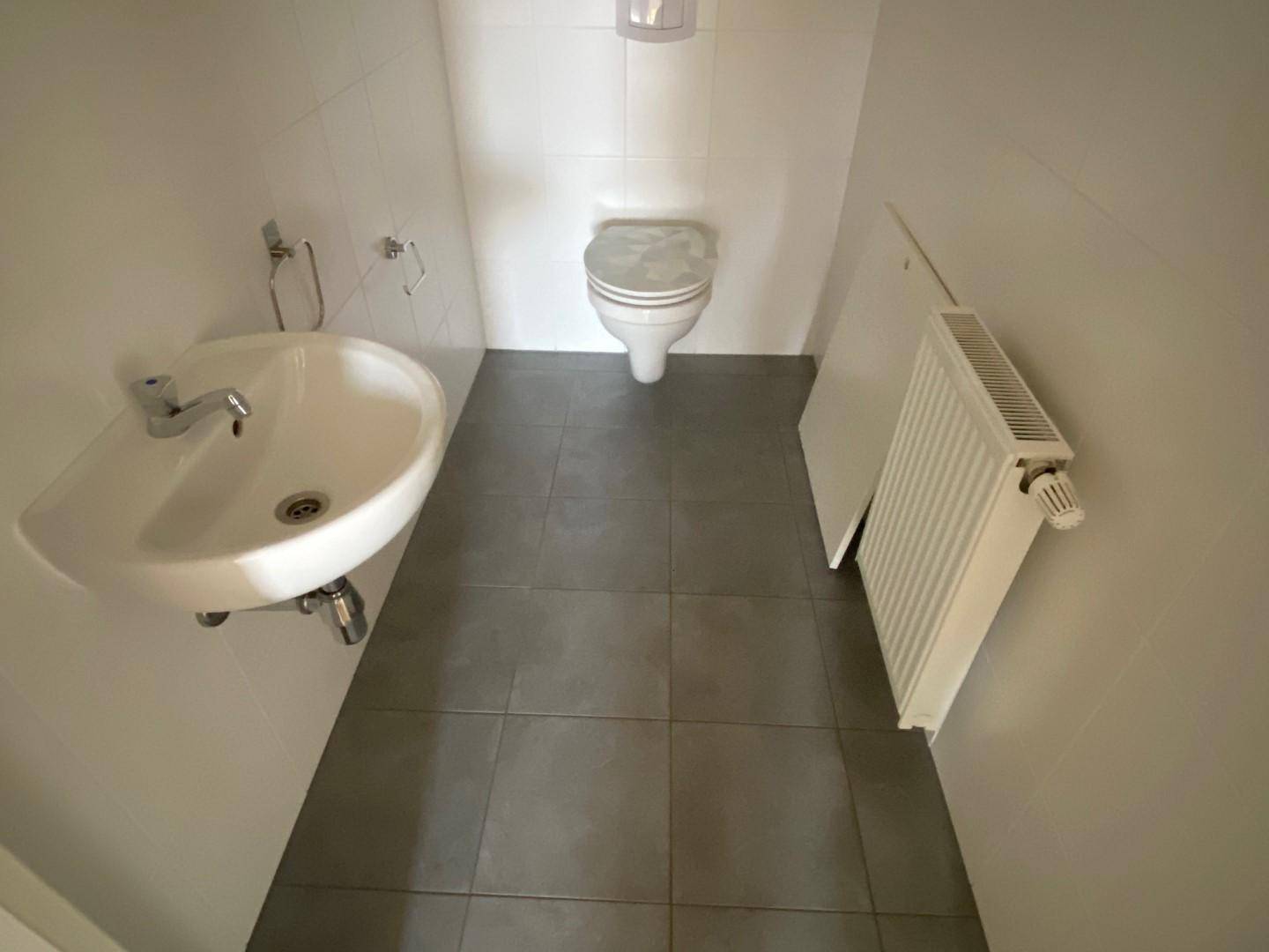 Separates WC mit Waschbecken, Toilette und Heizkörper, in gutem Zustand.