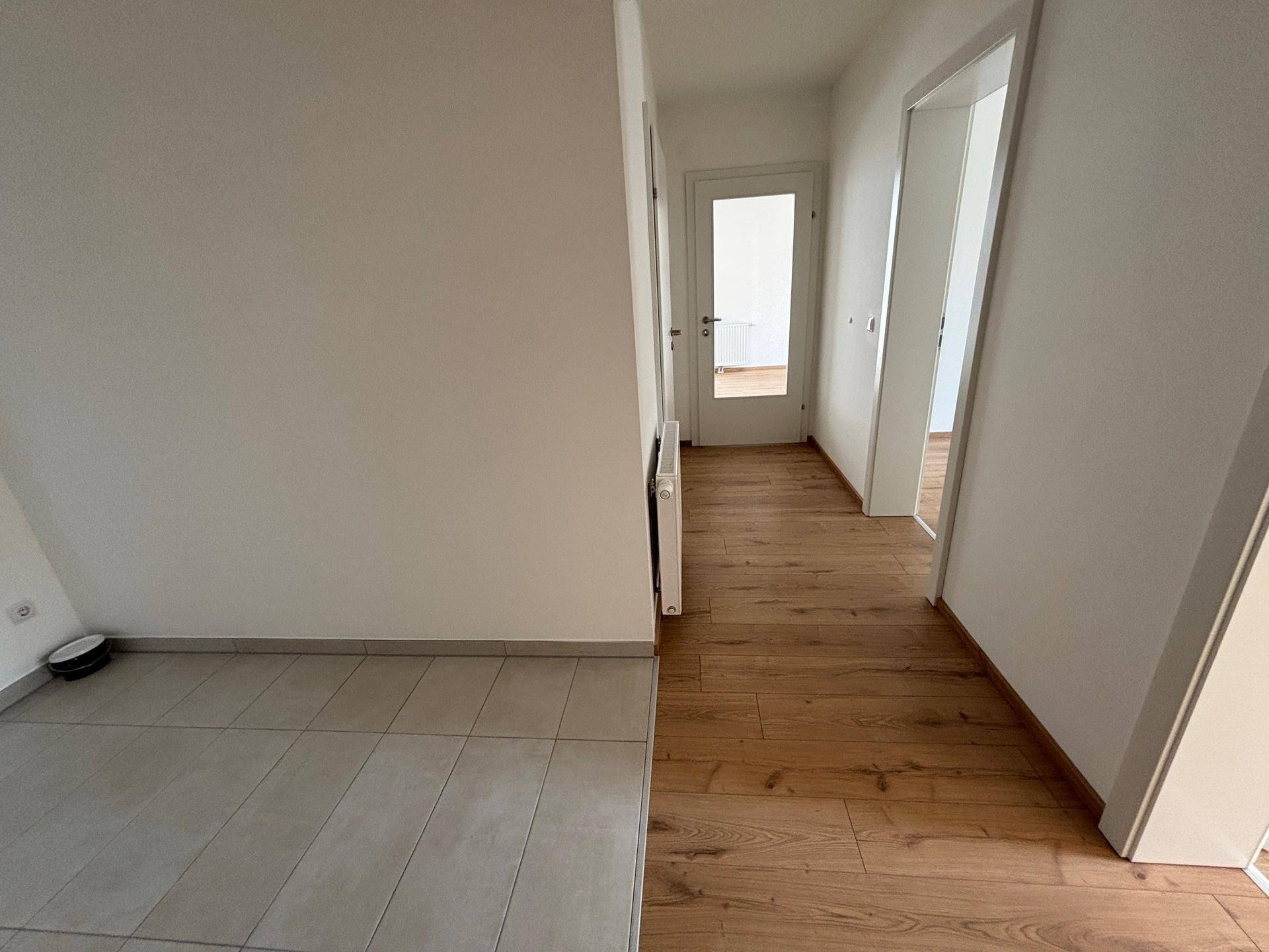 Heller Flur mit Laminatboden und Zugang zu weiteren Zimmern, modern und gepflegt.