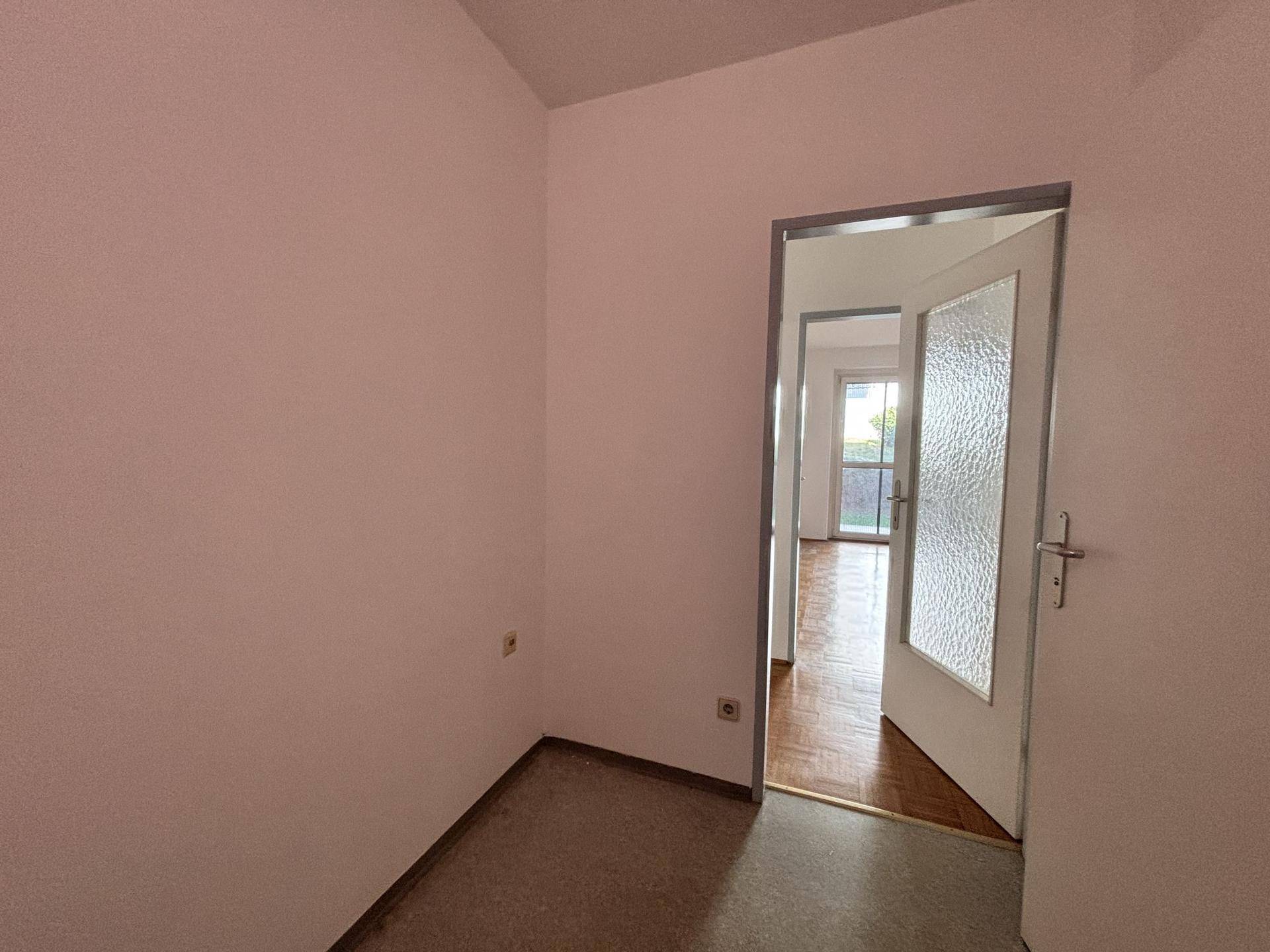 Heller Eingangsbereich mit schlichter Gestaltung und Blick in angrenzende Räume.