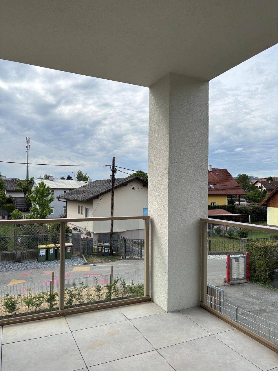 Geräumiger Balkon mit Fliesenboden und Blick auf die umliegende Wohngegend.