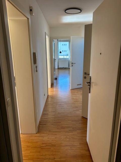 Heller Flur mit Parkettboden und Zugang zu verschiedenen Zimmern der Wohnung.