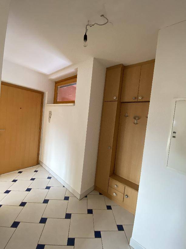 Heller Eingangsbereich mit integrierter Garderobe und Fliesenboden.