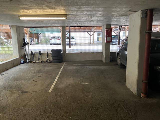 Tiefgarage mit Betonboden und Abstellmöglichkeiten für Fahrzeuge und Sportgeräte.
