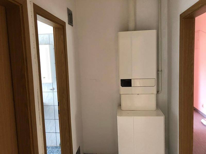 Flur mit Heizungsanlage und Zugang zu weiteren Räumen.
