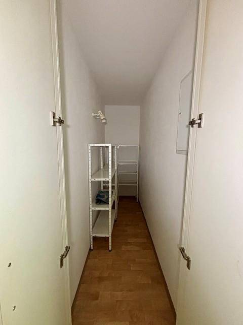 Praktischer Abstellraum mit Regalen für zusätzlichen Stauraum und Laminatboden.