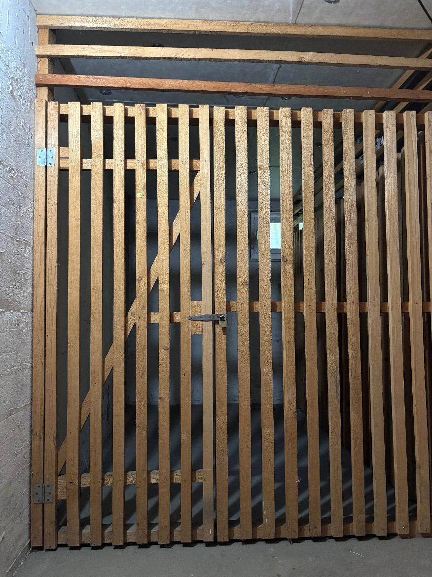 Holzlattentür eines Kellerabteils, bietet sicheren und belüfteten Stauraum.