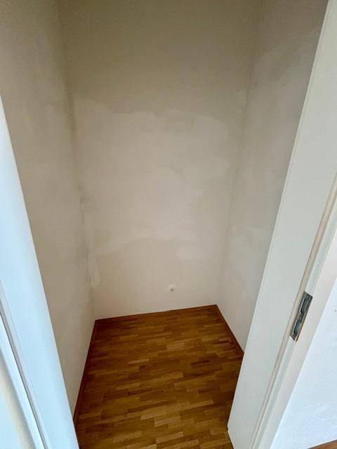 Kleiner, leerer Abstellraum mit Parkettboden und weißen Wänden, ideal für zusätzlichen Stauraum.