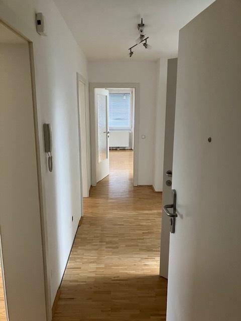 Langer Flur mit hellem Parkettboden, verbindet die verschiedenen Wohnbereiche der Wohnung.