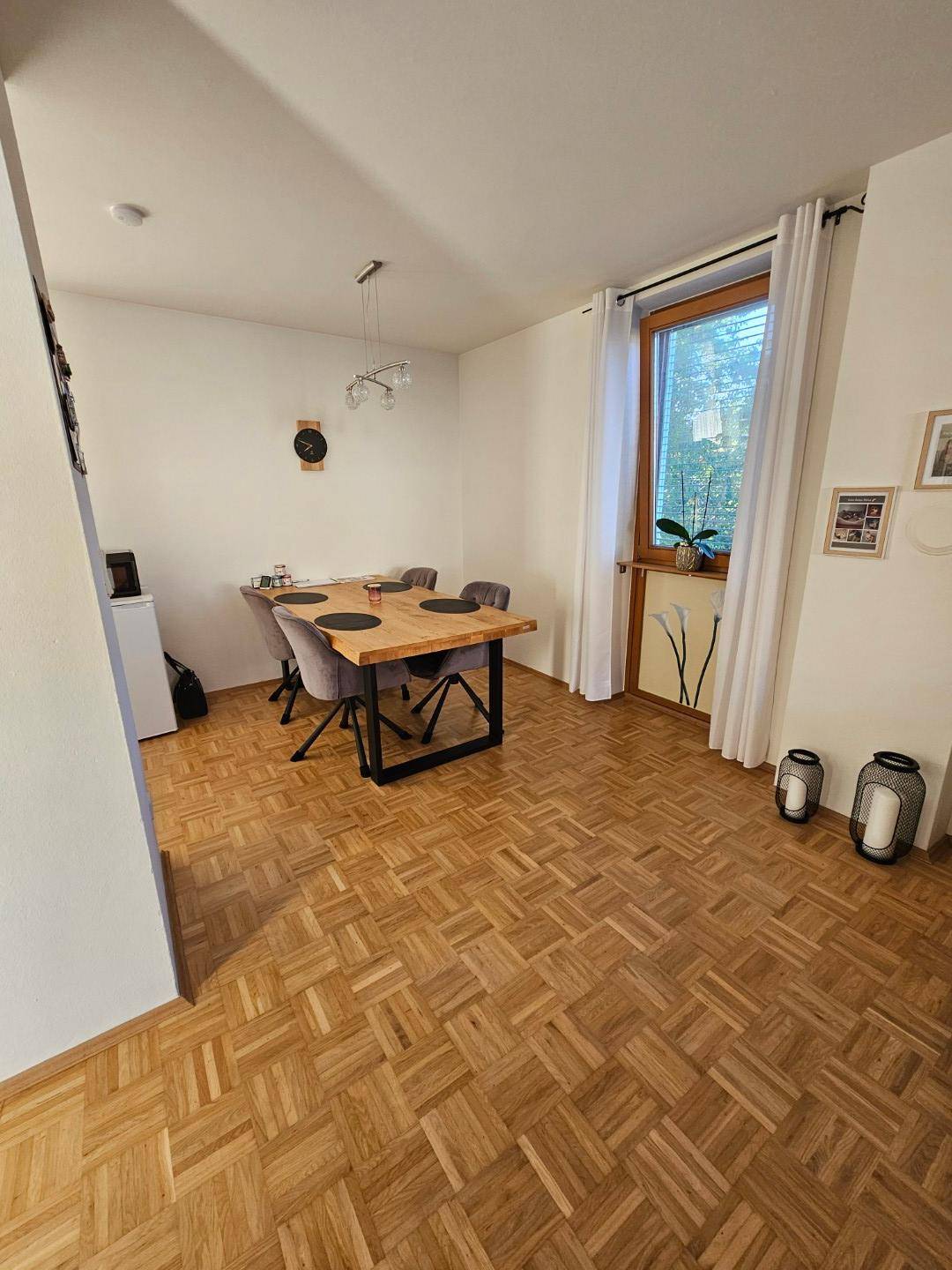 Heller Essbereich mit Holztisch, modernen Stühlen und Parkettboden.