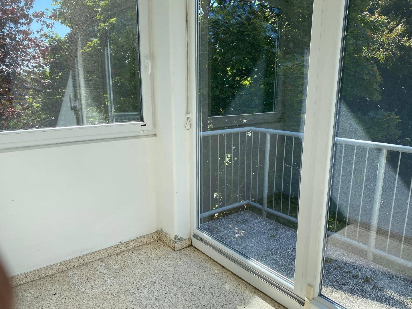 Verglaste Loggia mit Blick ins Grüne, ideal für entspannte Stunden im Freien.