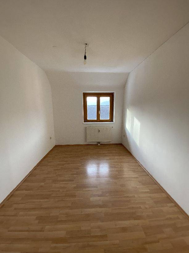 Geräumiges Schlafzimmer mit Holzboden und viel natürlichem Licht.