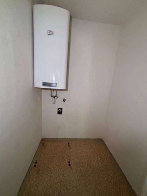 Kleiner Abstellraum mit Warmwasserboiler und einfacher Ausstattung.